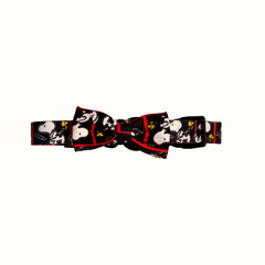 Coleira do Snoopy Zooz para animal, de padrão preto e branco, com detalhes vermelhos, imagens do personagem e um laço do mesmo padrão. Vista frontal, de vários tamanhos, sobre fundo branco.