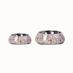 Comedouros ZOOZ para animal, disponíveis em dois tamanhos, com design do Snoopy, featuring ilustrações coloridas do personagem e elementos como pegadas e ossos. Material de plástico, com interior em alumínio. Vista lateral sobre fundo branco.